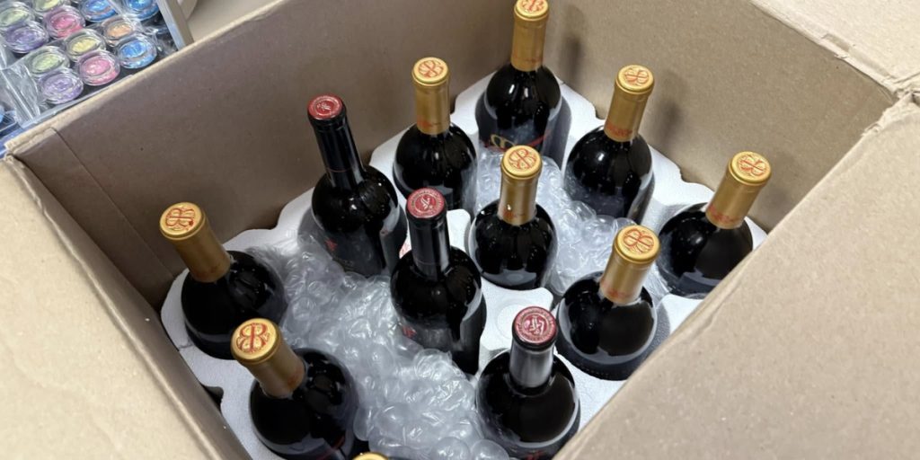 A box of wine bottles secured with molded inserts and bubble wrap to prevent cold-related damage during transit, illustrating winter wine shipping tips.