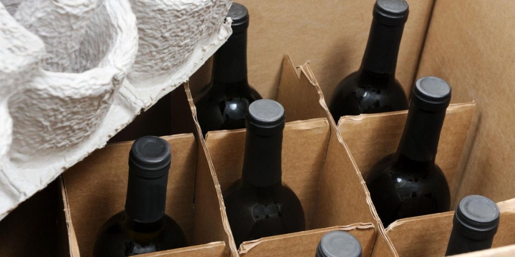 Best time of year to ship wine bottles packed securely in cardboard box with protective wrapping and insulation material demonstrating proper wine packaging and shipping protection methods.