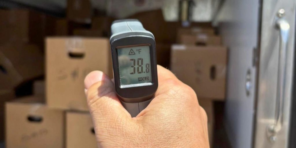 Best time of year to ship wine digital thermometer displaying 78.8 degrees Fahrenheit monitoring temperature control in storage area with cardboard wine boxes in background.