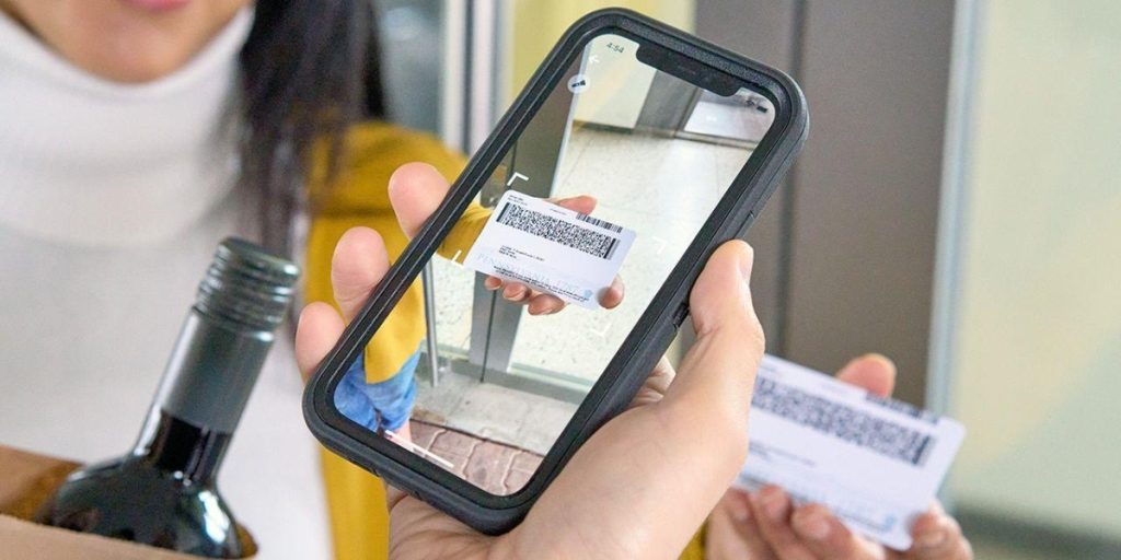 Adult signature wine delivery – customer scanning delivery barcode with mobile phone camera for wine package verification and digital signature confirmation of age-restricted beverage receipt