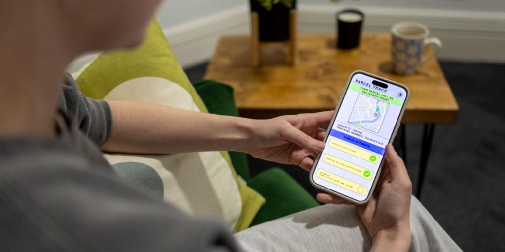 A person checks a parcel tracking app on their phone to monitor the status of a missed wine delivery.